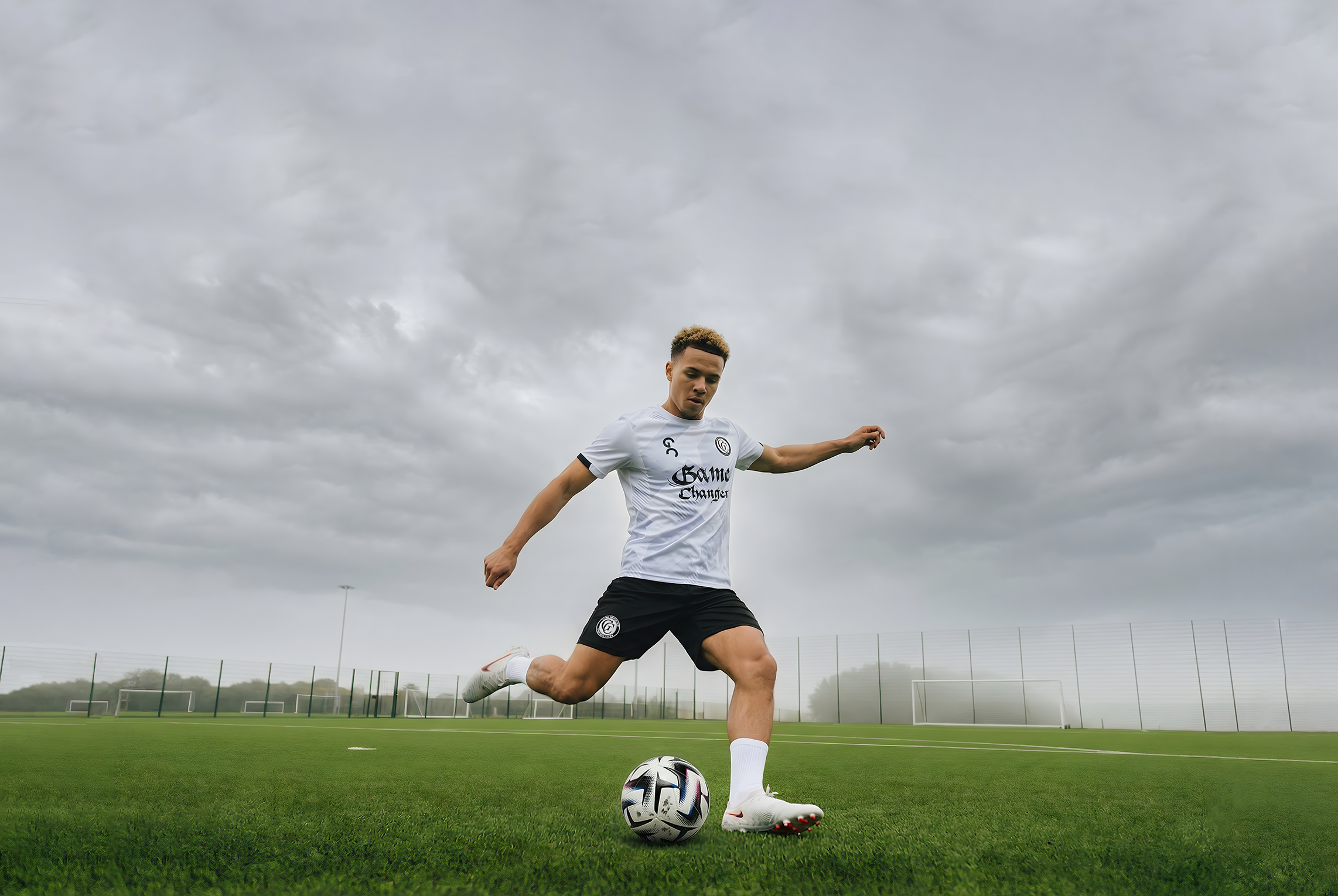 Joueur avec un maillot Game Changer qui frappe dans un ballon, le joueur porte des chaussettes antidérapantes